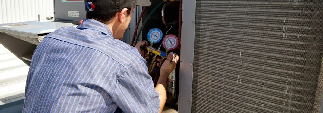 HVAC technician servicing a condenser unit in Palm Springs