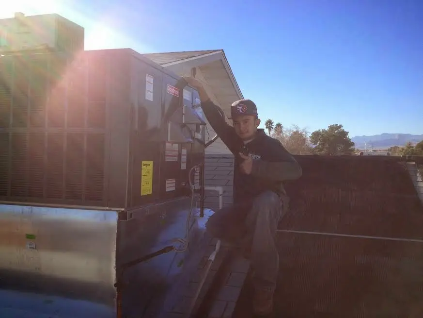 HVAC technician performing AC Tune-Up on a rooftop unit in Palm Springs
